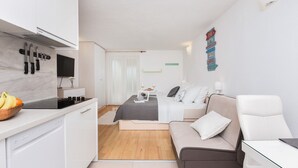 Um espaço de estar moderno e compacto, com cozinha compacta, cama e área de estar.