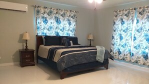 Ein Schlafzimmer mit einem Bett, zwei Nachttischen und Vorhängen.