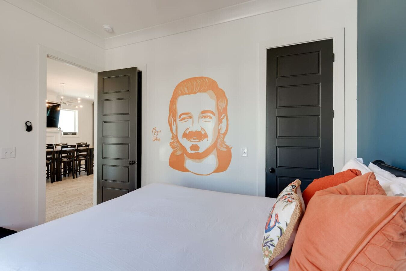 A bedroom with a bed, two doors, and a wall mural.