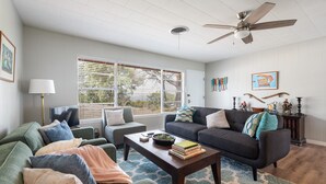 A living room with a sofa, armchairs, a coffee table, and a ceiling fan. - Hillside Paradise near Hidden Falls! Clean 3/1.5, Expansive views (Marble Falls)