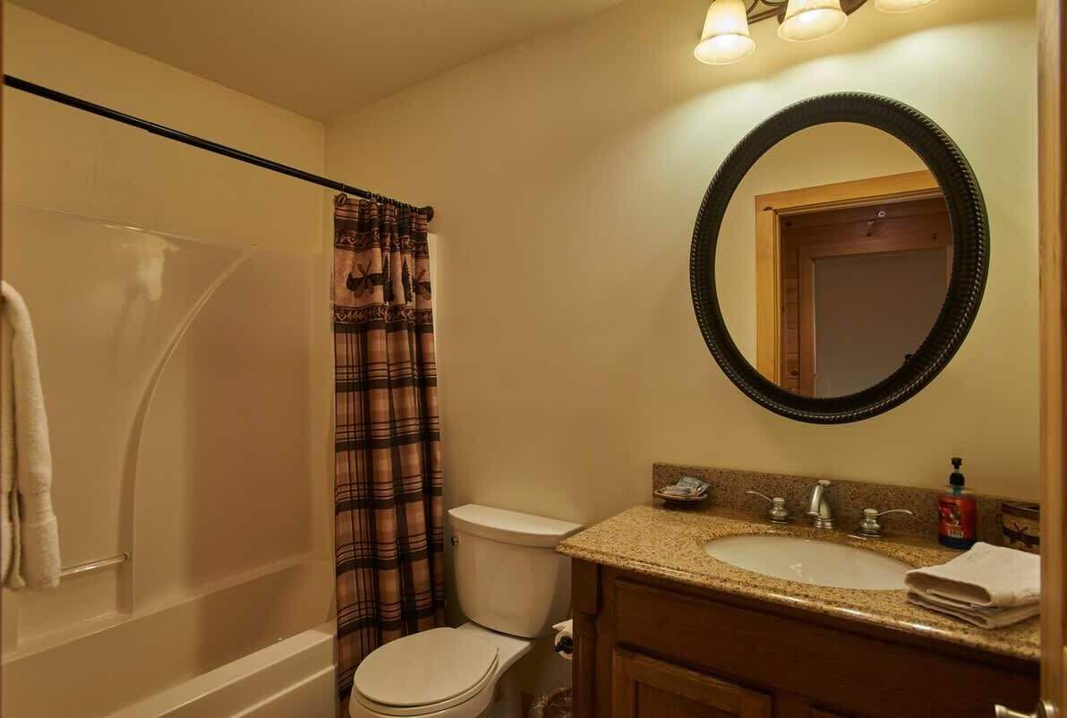 A bathroom with a bathtub, toilet, and sink.