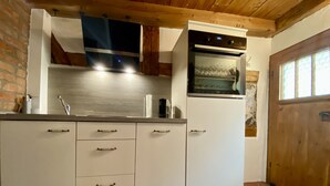 A kitchen with white cabinets, a built-in oven, and a sink. - My mini house | 2 rooms | Smart TV | Stone & wood (Karlsruhe)