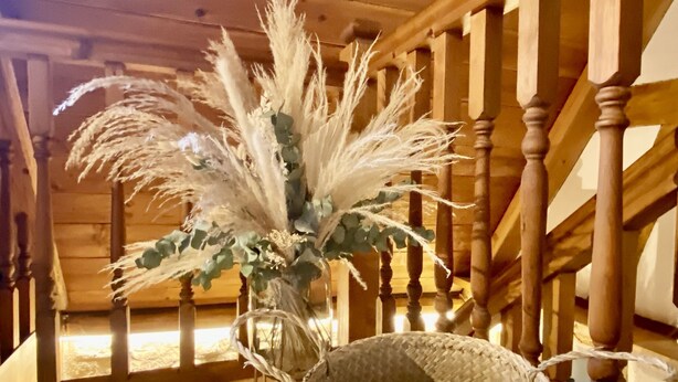 A wooden staircase with a woven basket containing pampas grass and a light blue throw blanket. - My mini house | 2 rooms | Smart TV | Stone & wood (Karlsruhe)
