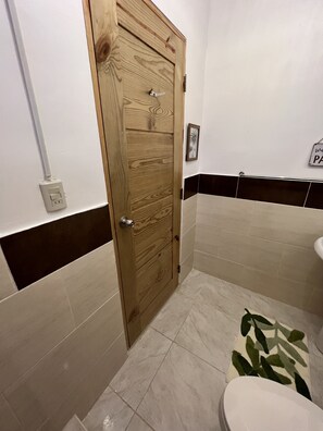 Een douche, handdoeken, zeep, toiletpapier