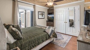 A bedroom with a bed, a ceiling fan, a television, a wardrobe, and a door. - Bearway to Heaven - 2BR/2BA Condo, Downtown BR (Blowing Rock)