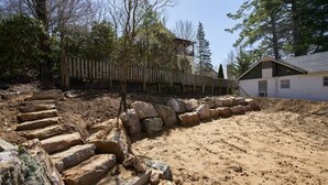Eine Baustelle mit freiliegenden Steinstufen und einem Holzzaun.