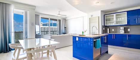 Suite de lujo, 2 habitaciones, cocina, vista parcial al océano | Área de sala de estar | Smart TV de 42 pulgadas con canales por cable y televisión