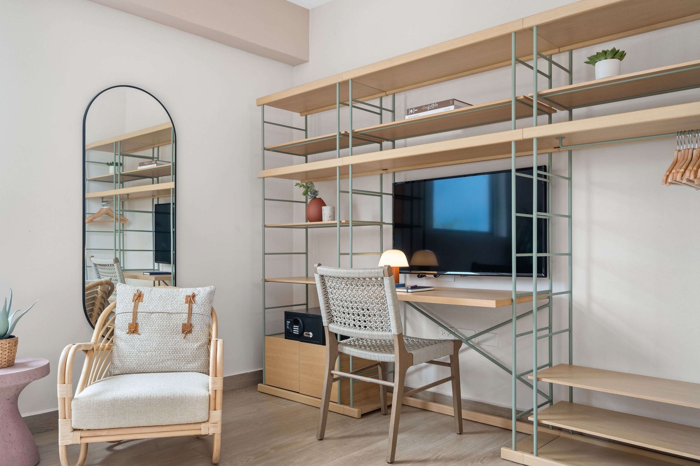 Un espace de travail moderne comprenant un bureau, une chaise, des étagères et un téléviseur.