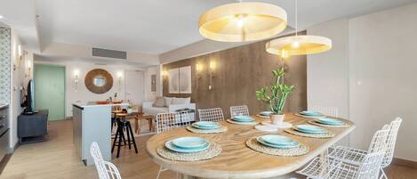 A modern dining area with a wooden table, white wire chairs, and blue plates.