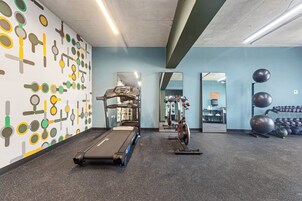Ein Fitnessraum mit Laufband, Ergometer und Übungsbällen.