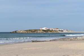 A beach with a building on a small island. - Casa do sapateiro (Ferrel)
