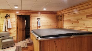 A wooden room with a massage table, a chair, and a door leading to another room. - Hot Tub! Cowboy Retreat! SW Wisconsin Driftless Region on UTV Route (Eastman)