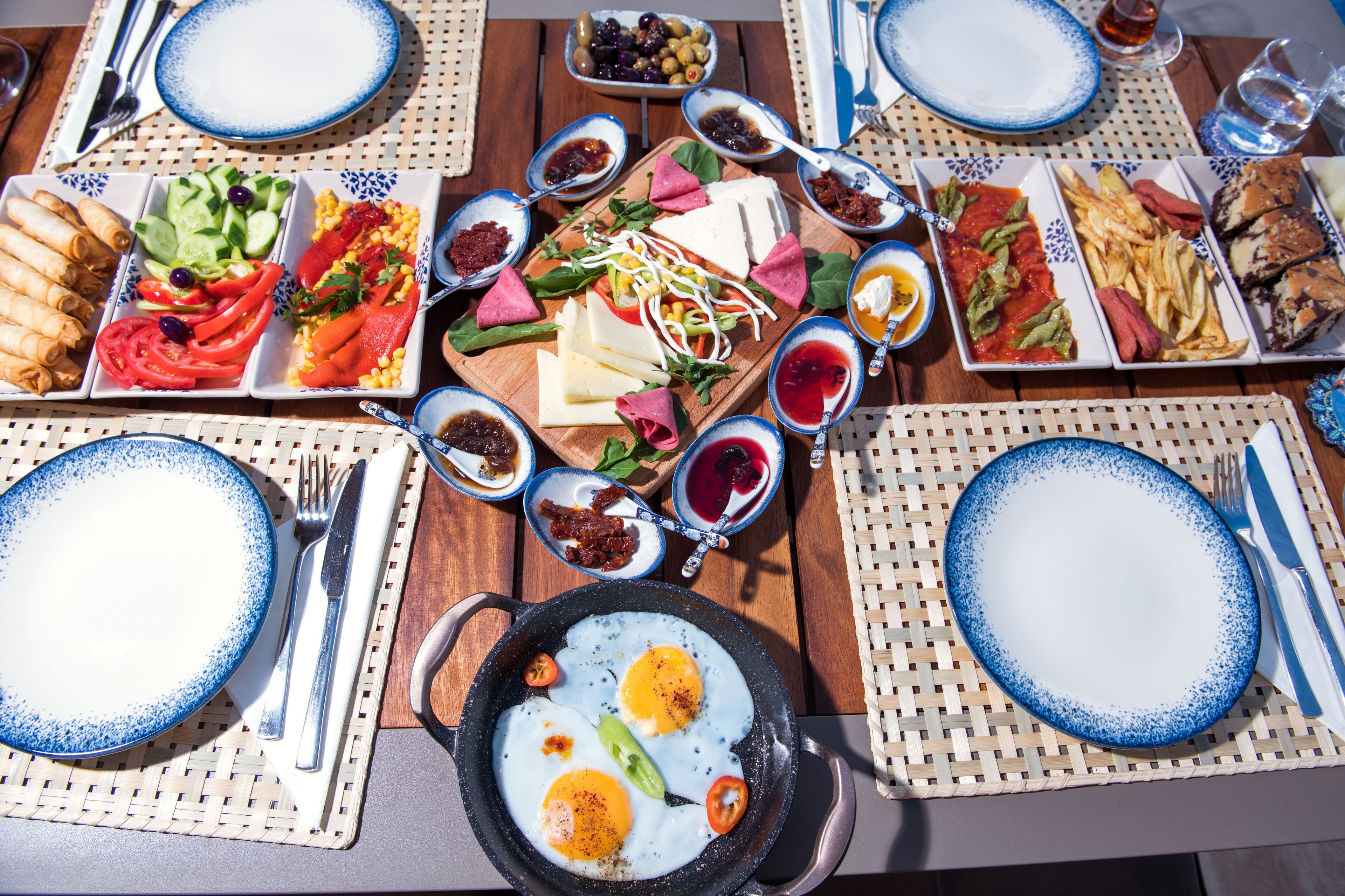 A table set for a meal with various dishes, including eggs, vegetables, and meats.