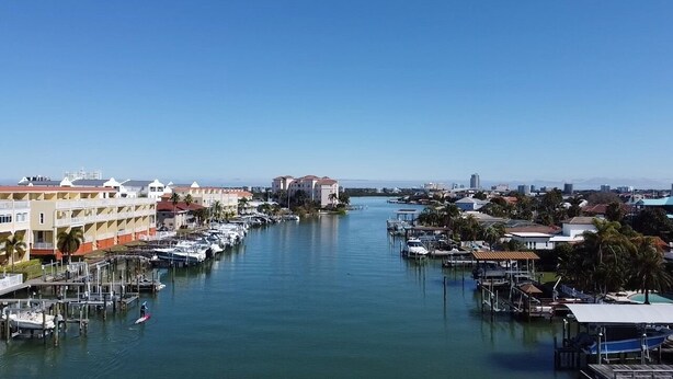 A marina with boats docked, a clear sky, and buildings along the waterfront. - Anchors UP #3; WALK to Beach/Bars/Dining (Clearwater Beach)