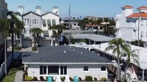 A waterfront property with a dock, white buildings, and a clear blue sky. - Anchors UP #3; WALK to Beach/Bars/Dining (Clearwater Beach)