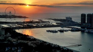 A coastal cityscape with a marina, a large Ferris wheel, and modern buildings. - Dubai Dream - Hotel Suite - Breathtaking view of Palm Jumeira +++ (Dubai)
