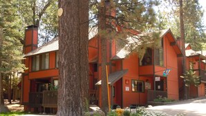 A two-story building with a red exterior, multiple balconies, and a fire hydrant in the front yard.