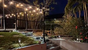Un foyer extérieur aménagé dans un espace paysager, avec un bâtiment en arrière-plan.