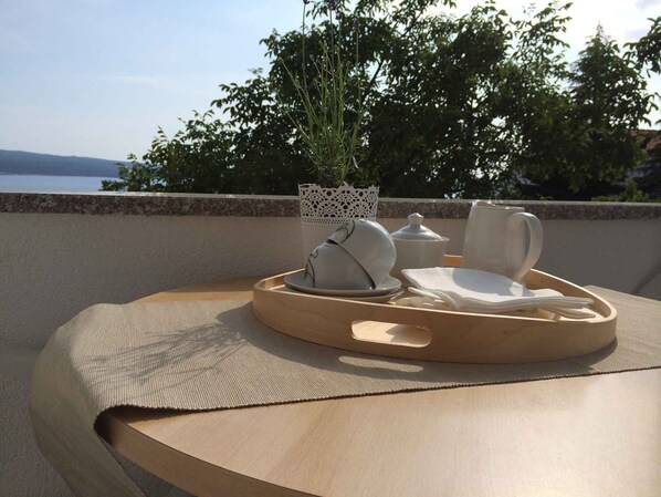 A table with a tray holding a teapot, cups, and a small plant.