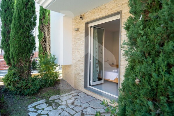 A modern building with a stone pathway leading to a glass door entrance.