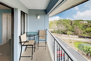 Enjoy the serene view from this balcony with a glass door leading to a cozy interior space.