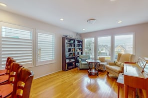 Relax in a spacious living room with a comfortable seating area, bookshelf, and large window.