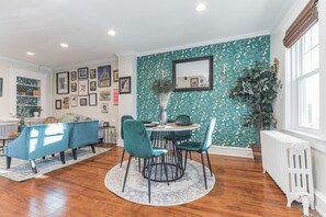 A dining area with a round table, teal chairs, and a patterned rug. - Homey Retreat in Historic Kennett Square!! (Kennett Square)