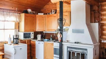 Cocina compacta con armarios de madera, un microondas, una cafetera y una estufa.