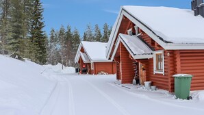 A snow-covered log cabin with a clear sky and a forest in the background. - Alppi 6b paritalo by Interhome (Hyrynsalmi)