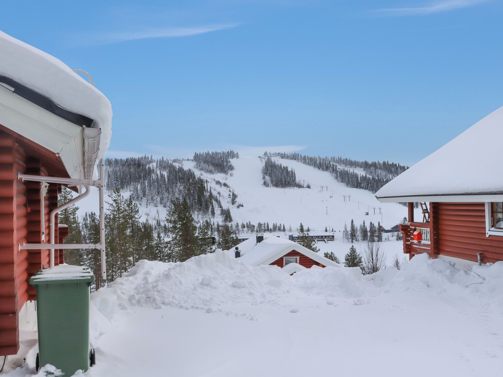 A snowy mountain landscape with cabins and a ski slope.