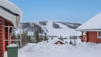 A snowy mountain landscape with cabins and a ski slope.