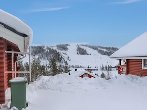 Un paysage de montagne enneigé avec des chalets et une piste de ski.