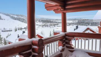 Ein hölzerner Balkon mit Blick auf eine verschneite Berglandschaft.