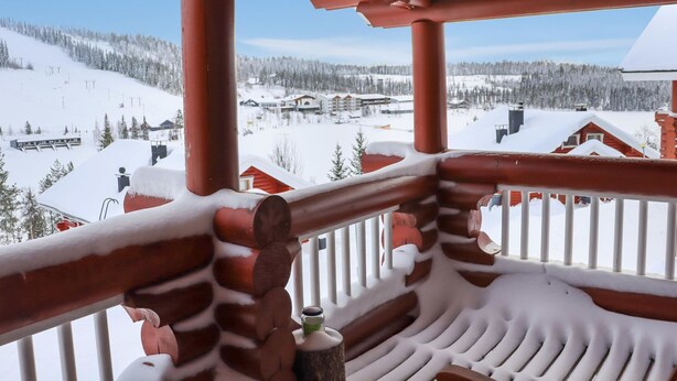 A wooden balcony with a view of a snowy mountain landscape. - Alppi 6b paritalo by Interhome (Hyrynsalmi)