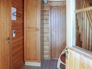 A wooden interior with a wardrobe, a door, and a window.