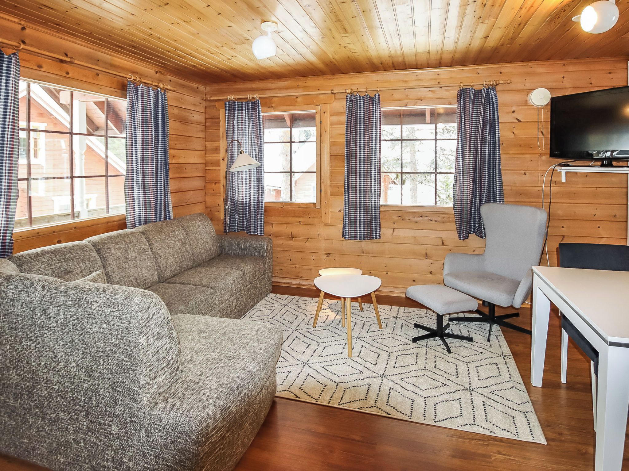 A cozy room with a sofa, a chair, a small table, and a TV.