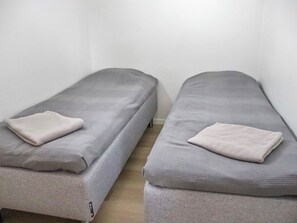 Two single beds with grey bedding and a folded blanket on each. - Alppikylä 4b by Interhome (Hyrynsalmi)