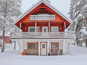 A two-story building with a balcony, a front door, and a bench. - Alppikylä 4b by Interhome (Hyrynsalmi)