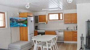 Een moderne keuken met houten kastjes, een witte eettafel en een inbouwoven.