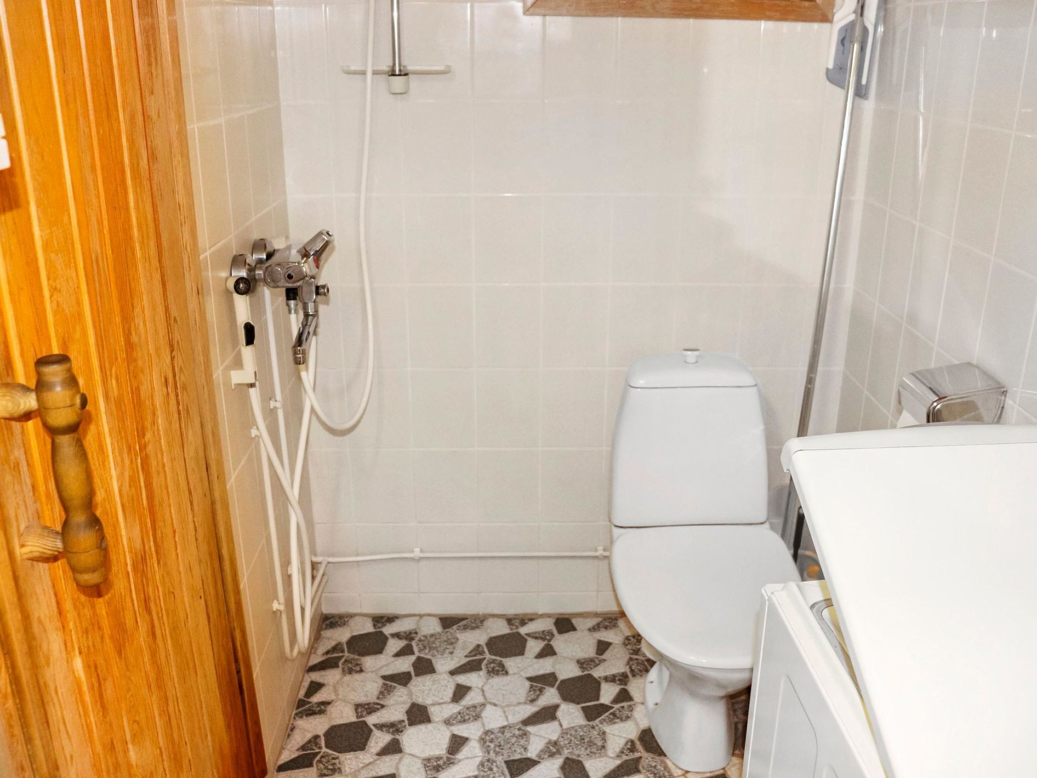 Une petite salle de bain avec des toilettes, une douche et un lavabo.