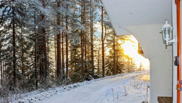 A snow-covered path leading to a building with a wooden deck and a white lantern. - Alppikylä 8b by Interhome (Hyrynsalmi)