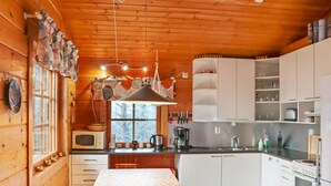 Une cuisine chaleureuse avec des murs en bois, une table à manger et des appareils électroménagers modernes.