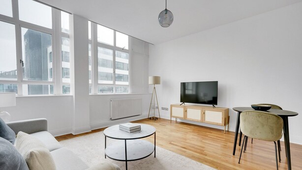 A modern living room with a sofa, coffee table, TV, and dining area. - Charming Old Street 1BR, 5 min walk to Old Street Tube, by Blueground (London)