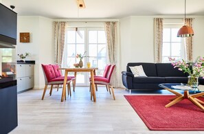 A modern living room with a dining area, a sofa, and a coffee table.