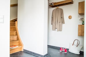 Una escalera con escalones de madera y una pared blanca.