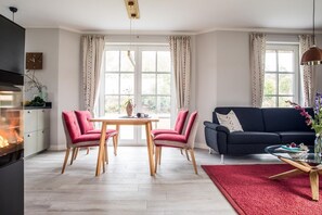 Una sala de estar moderna con comedor, sofá y chimenea.