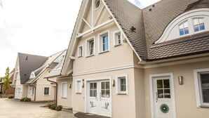A row of modern houses with gabled roofs and white doors.