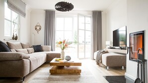 A modern living room with a sectional sofa, a wooden coffee table, a TV, and a fireplace.