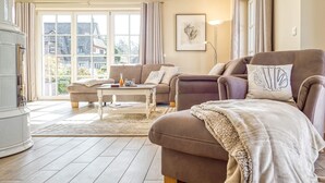 A spacious living room with a sofa, armchair, and coffee table.