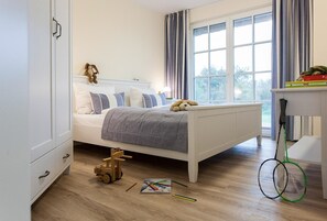 Un dormitorio con una cama, un juguete de madera y una raqueta de bádminton.